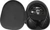 An open black carrying case for headphones, showing the headphones and charging cables inside. Produktbild-Vorschau