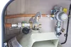 Close-up view of a gas regulator and hose connection on a gas cylinder, likely in a recreational vehicle or similar setting. Produktbild-Vorschau