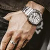 A close-up shot of a person's hand wearing a silver watch and a ring. Voir les images du produit