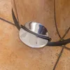 A close-up of a stainless steel pedal on a trash can, resting on a tiled floor. Produktbild-Vorschau