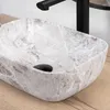 A close-up shot of a marble sink with a black faucet. Náhled obrázku produktu