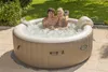 A couple relaxing in an inflatable hot tub outdoors on a patio. Produktbild-Vorschau