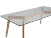 A close-up, angled view of a rectangular glass-top coffee table with a wooden frame and legs, set against a white background. Náhľad obrázku produktu