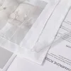 A close-up view of a sheer curtain with a decorative element and text on paper underneath. Produktbild-Vorschau