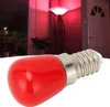 A red LED light bulb is shown in the foreground, with a blurred background of a room illuminated by red light. Podgląd zdjęcia produktu