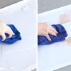 A split image showing a hand wiping a white surface with a blue cloth. The left side shows the cloth wiping a wet surface, and the right side shows the cloth wiping a dusty or dirty surface. Náhľad obrázku produktu