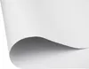 A close-up view of a white sheet of paper or fabric, with one corner curled upwards, casting a shadow. Produktbild-Vorschau