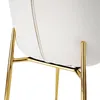 A close-up view of the base of a white chair with gold legs. Produktbild-Vorschau
