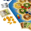 A close-up view of the board game "Siedler aus Katan" with game pieces, dice, and cards. Náhled obrázku produktu