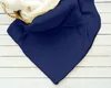 A navy blue blanket is folded and partially placed in a woven basket with a white fluffy lining, resting on a white wooden surface. Produktbild-Vorschau