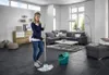 A woman is mopping a floor in a modern living room. Náhled obrázku produktu