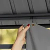 A hand is shown attaching a gray curtain to a gazebo track. Produktbild-Vorschau