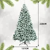A flocked artificial Christmas tree with a stand, set against a snowy background with fir branches at the top and bottom corners. Dimensions are indicated with text overlays. Produktbild-Vorschau