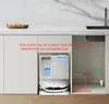 A robot vacuum cleaner and its docking station are shown in a kitchen setting, with text indicating water inlet and outlet connections. Produktbild-Vorschau
