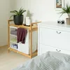A laundry basket with clothes and a plant next to a dresser. Náhled obrázku produktu