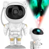 A white astronaut projector lamp is shown on a gray base, with a smaller astronaut figure to the right. A colorful nebula projection emanates from the smaller astronaut's head. Anteprima dell’immagine prodotto