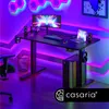 A modern gaming desk setup with a computer, laptop, and ambient lighting. Anteprima dell’immagine prodotto