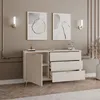 A modern beige sideboard with gold accents, featuring fluted drawers and an open cabinet, displayed in a well-lit room with abstract art on the wall. Produktbild-Vorschau
