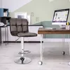 A bar stool is placed next to a wooden desk with a computer in a home office setting. Produktbild-Vorschau