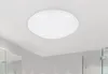 A white, round ceiling light fixture is mounted on a white ceiling in what appears to be a modern bathroom. Náhled obrázku produktu
