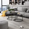 A modern living room with a sectional sofa, coffee tables, and a bookshelf. Voir les images du produit