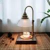 A candle warmer lamp with a candle on a bamboo mat. Anteprima dell’immagine prodotto