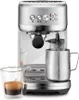 A silver espresso machine with a steaming pitcher and a shot glass of espresso. Produktbild-Vorschau