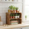 A kitchen counter with a wooden crate shelf displaying potted herbs, bottles of oil, and books. Náhled obrázku produktu