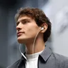 A man wearing earphones outdoors. Produktbild-Vorschau
