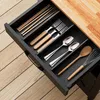 A close-up view of a kitchen drawer organizer filled with cutlery and kitchen utensils. Podgląd zdjęcia produktu