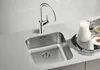 A stainless steel kitchen sink with a modern faucet, next to a pitcher of milk and a bowl of cereal on a tray. Produktbild-Vorschau