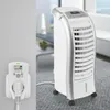 A white air cooler is shown plugged into a wall socket with a digital display, in a living room setting. Podgląd zdjęcia produktu
