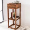 A wooden side table with a drawer and shelves, decorated with books and a vintage telephone. Náhľad obrázku produktu