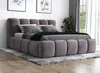 A modern upholstered bed with a headboard and footboard, set up in a bedroom with a rug underneath and artwork on the wall. Produktbild-Vorschau