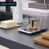A kitchen counter with a digital scale, a measuring cup with oats, a block of butter, and a bottle of milk. Náhled obrázku produktu