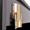 A close-up shot of a metal bracket attached to a dark wooden surface. Produktbild-Vorschau