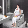 A pregnant woman sits on a shower chair in a modern bathroom. Náhled obrázku produktu