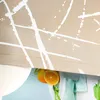 A close-up view of a fabric curtain with a white abstract pattern, with two oranges peeking out from underneath. Produktbild-Vorschau