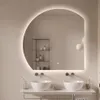 A modern bathroom with a large, illuminated, semi-circular mirror above two sinks. Produktbild-Vorschau