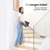 A woman is vacuuming a staircase with a cordless vacuum cleaner. Podgląd zdjęcia produktu