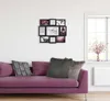 A collage photo frame is mounted on a white wall above a purple sofa with decorative pillows. A window with a vase of flowers is visible to the right. Produktbild-Vorschau