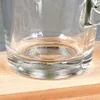 Close-up of the base of a clear glass mug on a wooden surface. Voir les images du produit