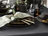 A table setting with plates, cutlery, a napkin, and a candle. Produktbild-Vorschau
