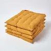 A stack of four mustard yellow seat cushions on a white background. Produktbild-Vorschau
