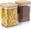 Two clear glass storage jars with bamboo lids, one filled with penne pasta and the other with coffee beans, are displayed against a white background. Produktbild-Vorschau