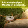 A string trimmer head with orange cutting lines rests on a rock in a grassy area. Produktbild-Vorschau