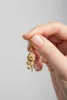 A hand holding a gold rose charm. Anteprima dell’immagine prodotto