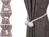 A close-up of magnetic curtain tie-backs with decorative balls, shown holding back a dark gray textured curtain. The left side of the image features a collage of three smaller images demonstrating different ways to use the tie-backs. Náhľad obrázku produktu