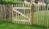 A wooden fence with a gate in a garden setting. Anteprima dell’immagine prodotto
