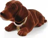 A brown plush dachshund figurine with a collar and tag, lying down on a white background. Produktbild-Vorschau